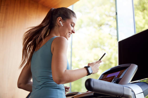 Woman Exercising On Treadmill and enjoying her workout 