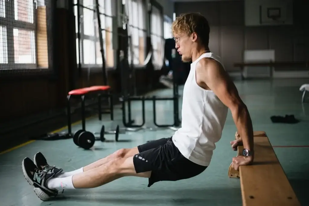 Young men doing triceps dips at home - strength training with no equipment