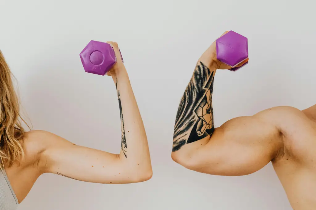 The man and woman are holding dumbbells and showing their biceps during strength training in the New York City