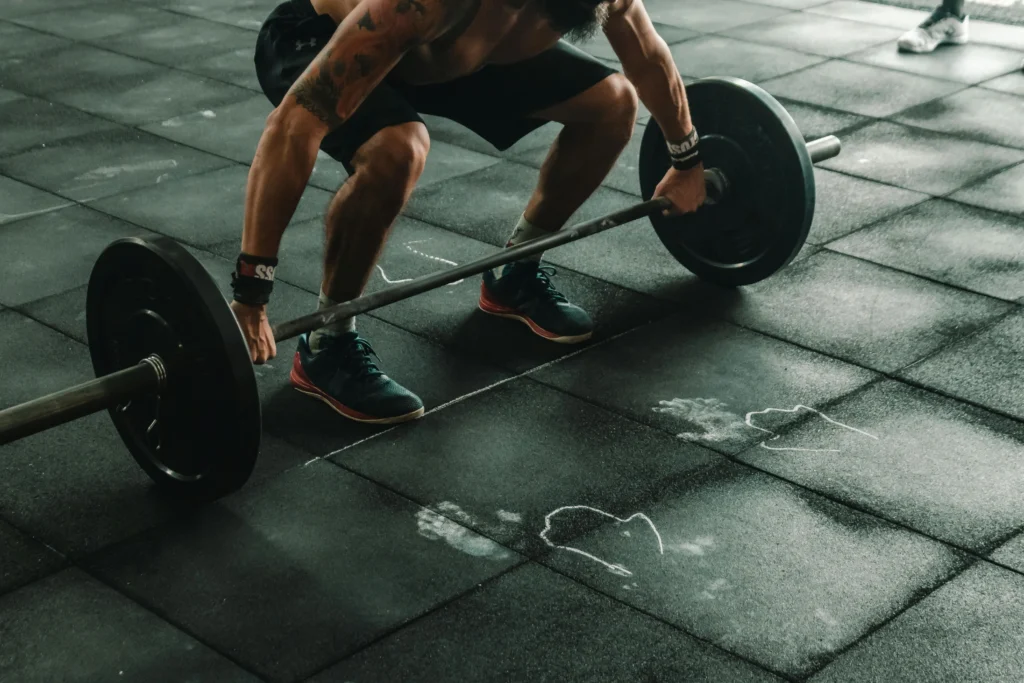 Person lifting a heavy barbell, emphasizing strength training and muscle retention during cutting.