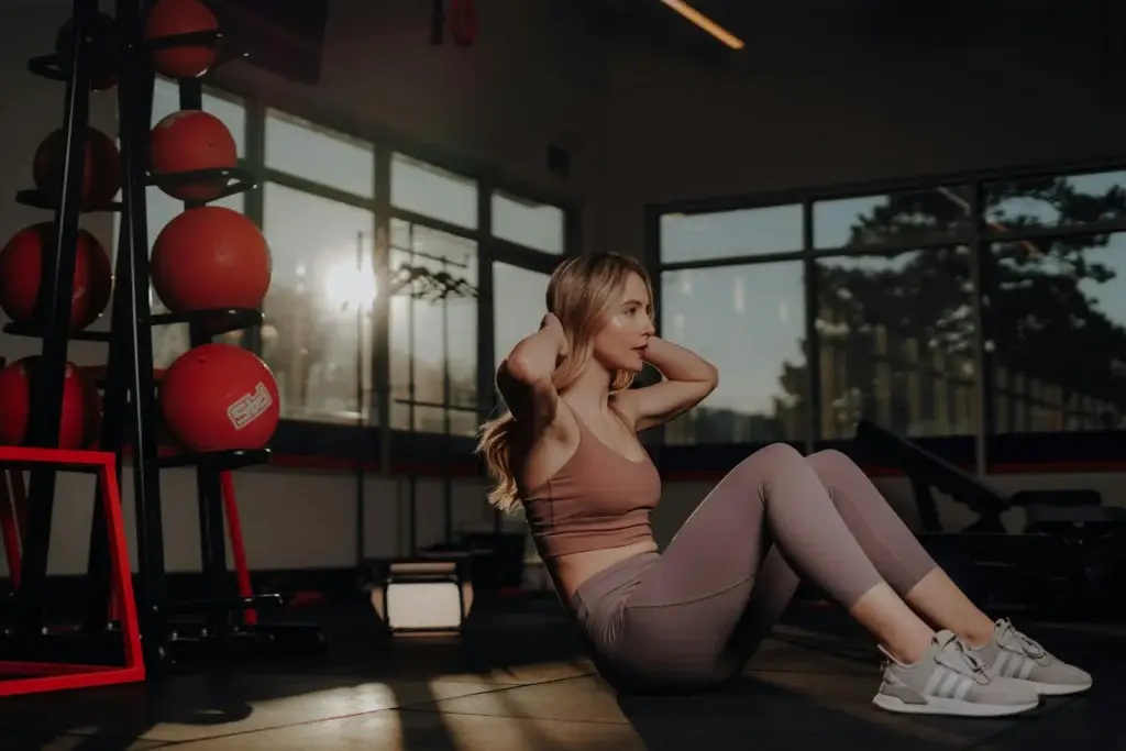 Woman doing sit-ups in home gym, focusing on core strength as part of a cutting workout routine.