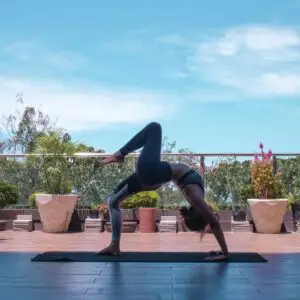 A woman in black leggings and black tank top doing yoga in San Francisco.