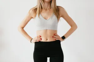 Motivated woman showing her belly to inspire others to lose belly fat and adopt a healthier lifestyle.