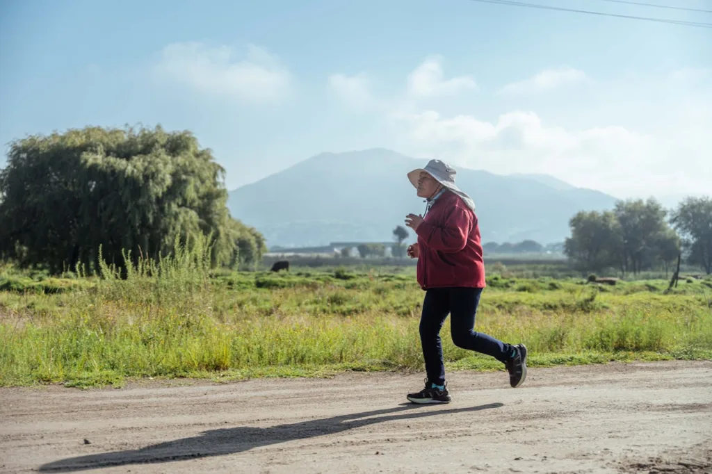 Elderly man walking in nature, a part of gentle exercises promoting active and healthy living in America.