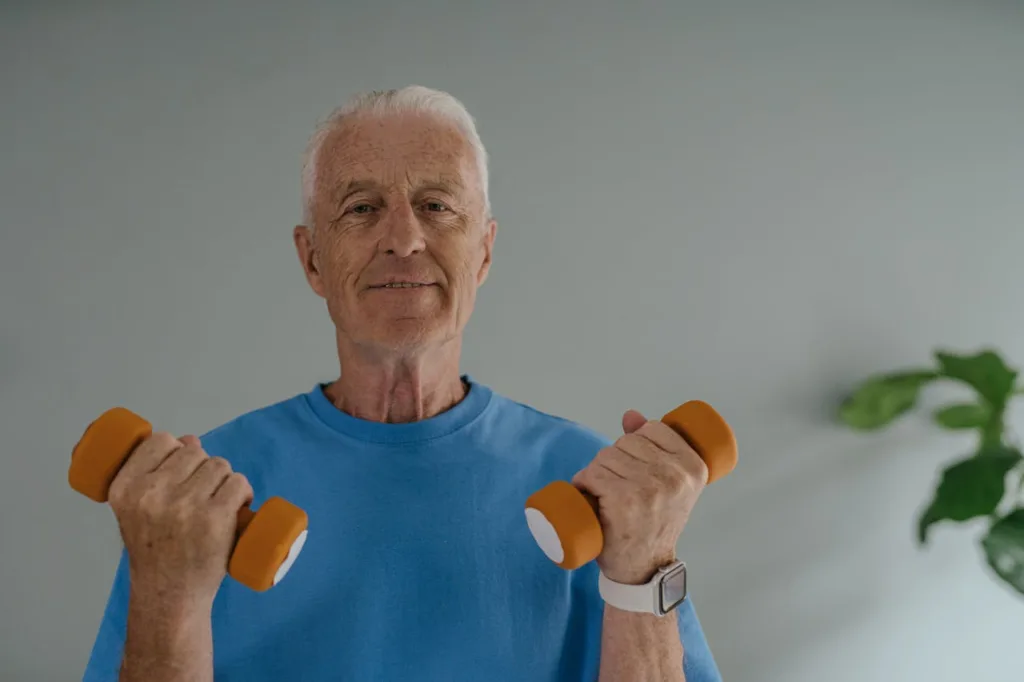 Elderly man performing gentle exercises with dumbbells, promoting strength and active living for Americans in their golden years.