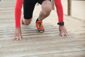 American athlete in a starting position wearing a smart fitness watch, showcasing cutting-edge AI-powered wearable fitness technology popular in the United States.